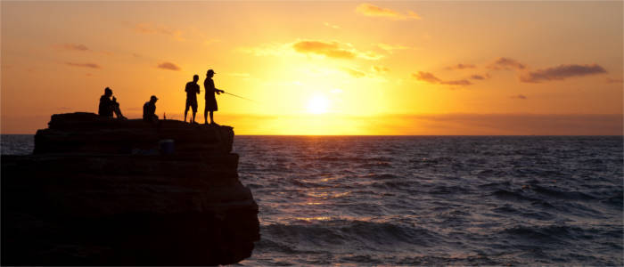 Anglers on a rock at the beach